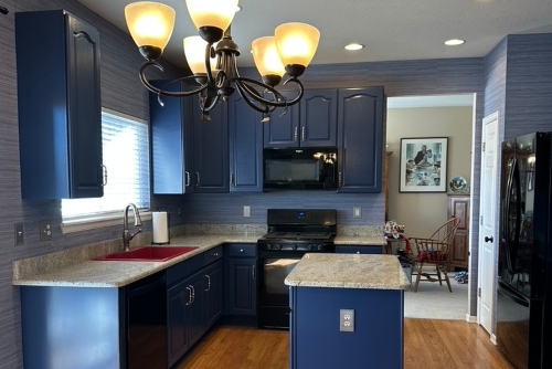 Fresh blue paint on cabinets with a red sink