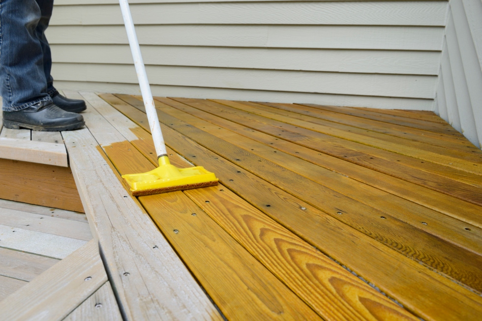 Worker Applying Stain to Deck