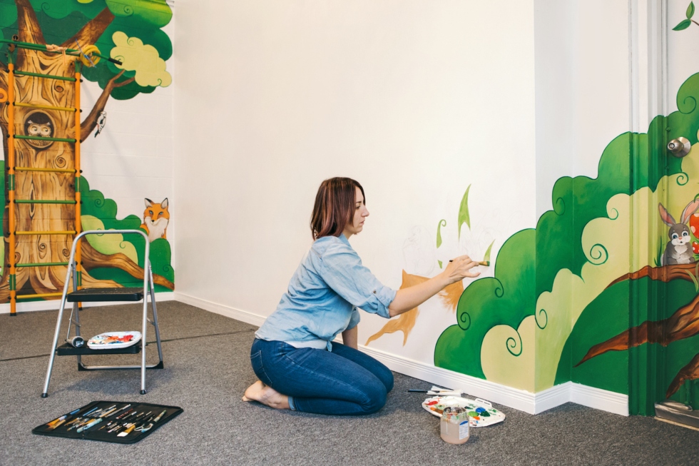 artist painting custom mural for kids areas