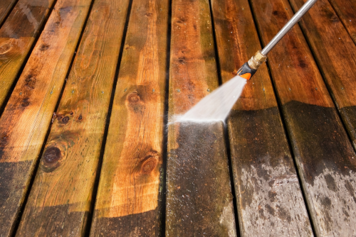 close up of pressure washing a deck