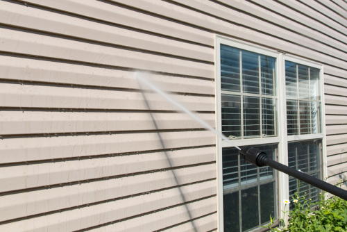 close up of pressure washing siding on a home