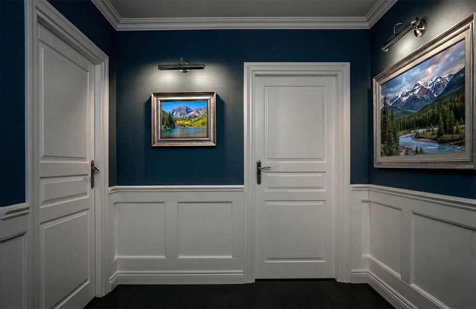 hallway with navy walls and white wainscoting and trim - colorado artwork