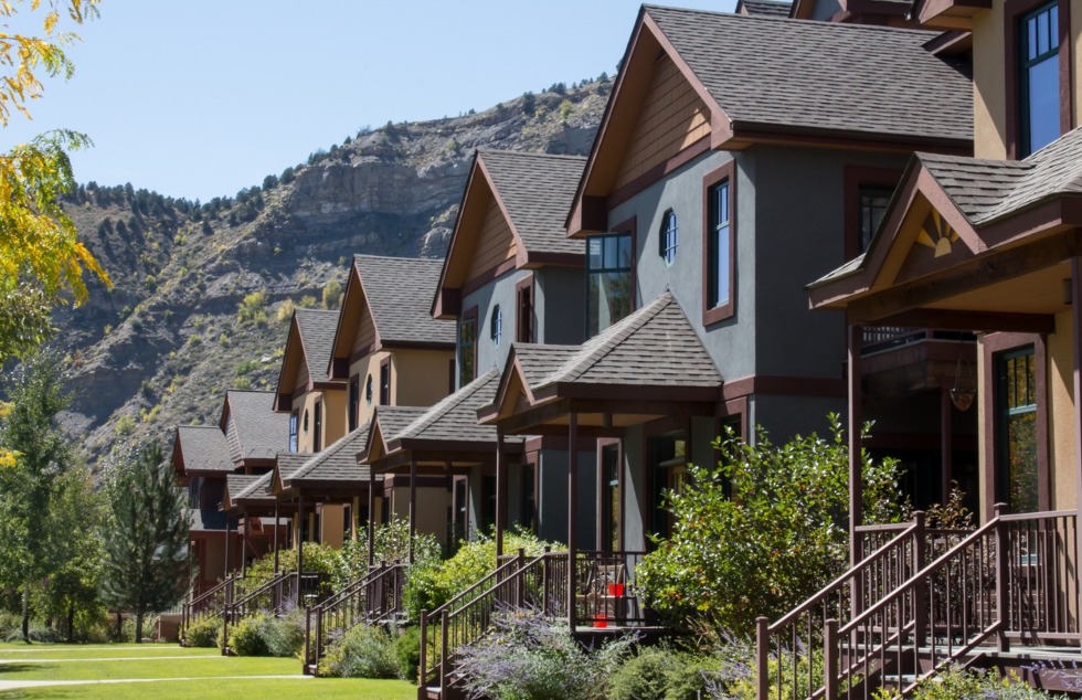 row of homes with painted stucco in front of mountain range