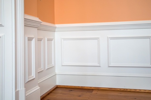 white chair rail on orange wall